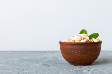 Fresh healthy Pistachios in bowl on colored table background. Top view Healthy eating concept. Super foods