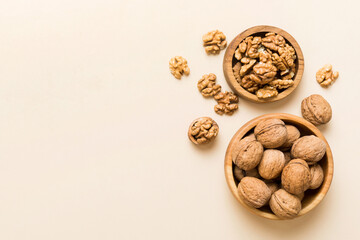 Walnut kernel halves, in a wooden bowl. Close-up, from above on colored background. Healthy eating Walnut concept. Super foods with copy space