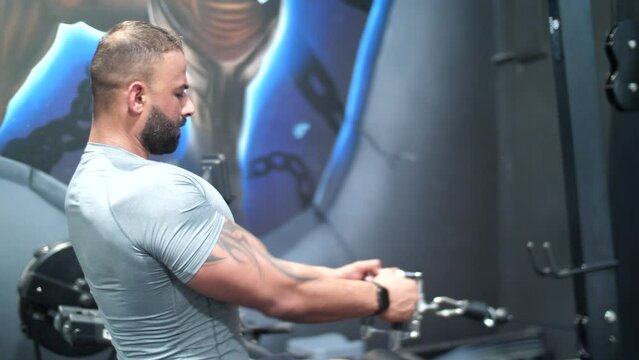 A muscular bodybuilder, passionately working out at the gym, lifts weights working on his backhand and chess