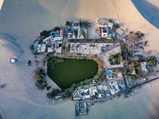Aerial top view of a lake surrounded by old buildings in a desert