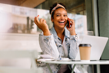 Happy businesswoman having a phone call at a café