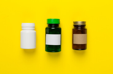 Plastic bottles with vitamins on color background, top view