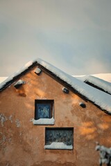 Winter scene featuring a building with a snow-covered roof and windows