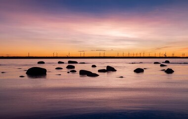 Landscape of the sea with long exposure surrounded by rocks during the sunset
