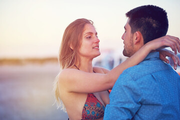 Obraz premium Couple, vacation and hug outdoor with love at the beach for travel, freedom and romantic date. Young woman and a man together on holiday to relax, bond and quality time with affection in nature