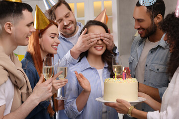 Happy friends with tasty cake celebrating birthday indoors