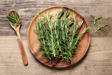 Fresh rosemary sprigs on wooden table, flat lay