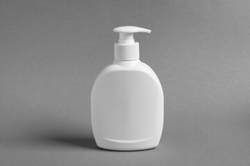 Bottle with cosmetic product on grey background