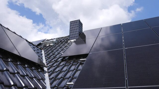 Solar panels on a gable roof shown in a panning shot