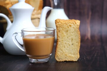 Tea Time Snack. Healthy Wheat rusk served with Indian hot masala tea and milk jug over black...