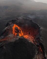 View of Fagradalsfjall volcano crater in Iceland, with a vibrant orange hue emitting from the lava - obrazy, fototapety, plakaty