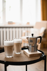 2 glasses of latte and a geyser coffee maker