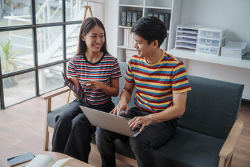 Happy married asian chinese couple sit at home office by paperwork business accounting. Glad young spouses read financial report get profit tax refund