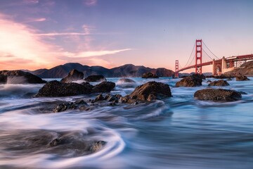 A time lapse shot of a river with the golden gate bridge in the background