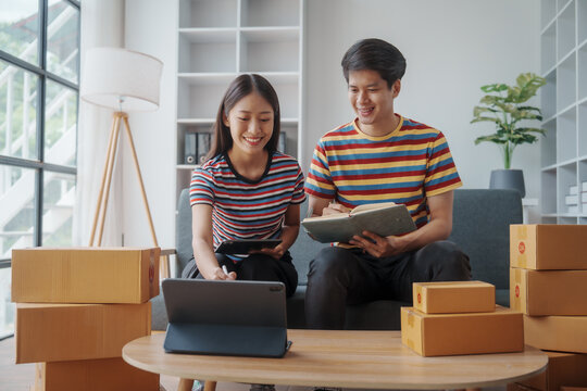 Two Chinese Couple Startup Small Business Owner Packing Goods For Delivery To Clients. Freelancer SME Man And Woman Selling Online Product On Social Media Application And Short Reel Video.