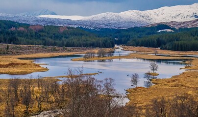 Tranquil Scottish landscape featuring a tranquil body of water surrounded by majestic mountains