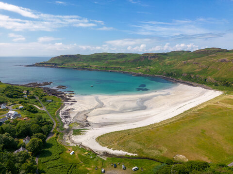 An aerial drone photo of Calgary Bay. This beautiful beach can be found on the Isle of Mull in Scotland. The beach has white sand and turquoise water. 