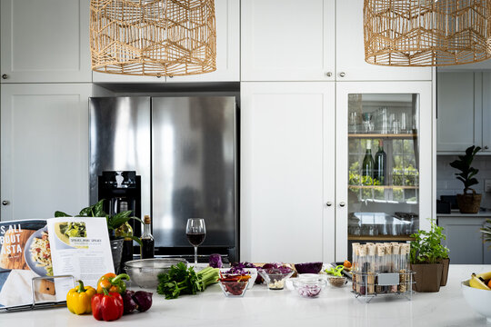 Vegetables, seasonings in bowls and flasks with spices on table in kitchen