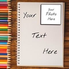 Holding text and photo space on notebook page, with row of coloured pencils on desk