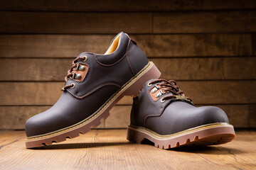 Stylish men's casual work boots for everyday walking in nature and the city on a wooden background...