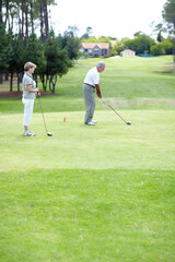 Obraz premium Old couple, sports or golfer playing golf for fitness, workout or exercise to swing on a course or field. Senior woman, elderly man golfing or training in practice game and driving with a club stroke