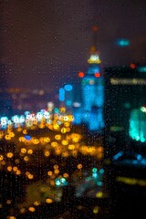 A bustling cityscape at night seen through a window with raindrops