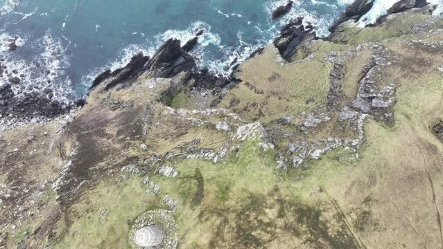 Drone view over a lighthouse on The Oa peninsula cliffs in Scotland
