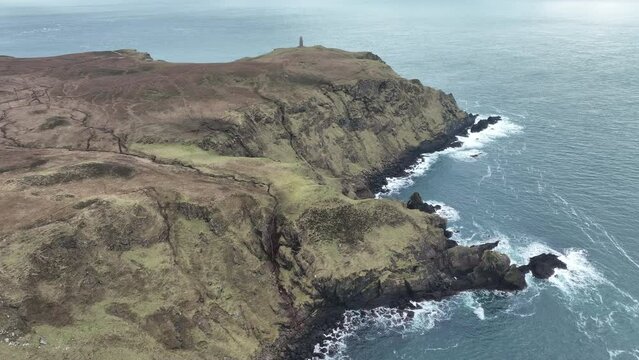 Drone view over a lighthouse on The Oa peninsula cliffs in Scotland