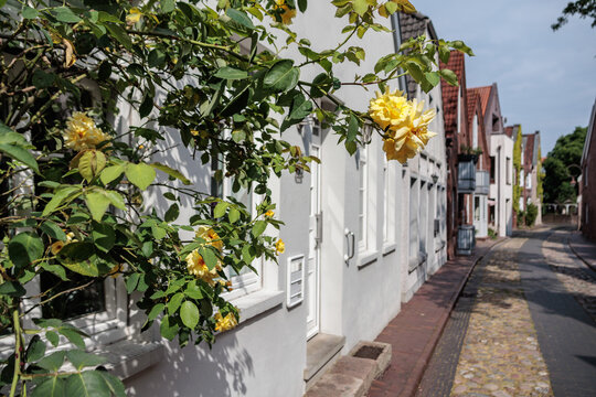 Historic residential buildings in Jever on a narrow cobblestone street