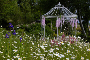 wild flowers in the garden with a gazebo 