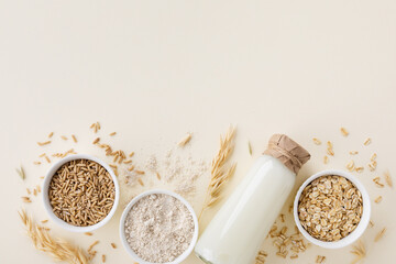 Oat products from flakes, milk, flour and whole grains top view. Healthy food, vegetarian diet concept. - obrazy, fototapety, plakaty