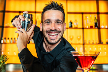 Handsome barman making cocktail at nightclub - Happy bartender working behind the bar - Beverage life style concept