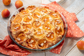 homemade pie with apricots and almonds on wooden background