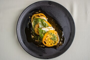 Succulent Caprese salad featuring fresh basil, mozzarella cheese, and juicy yellow tomatoes