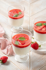 Italian dessert panna cotta in glass with strawberries.