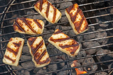 Grilled slices of halloumi cheese on grill in perspective