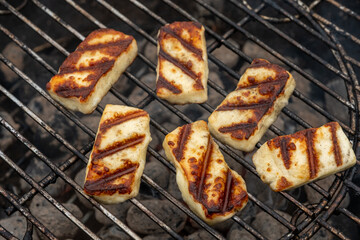 Grilled slices of halloumi cheese on grill in perspective