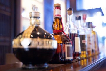 Whiskey bottles arranged in a row on the bar counter