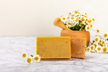 Natural homemade soap with chamomile flowers on a marble background. Spa procedure. Beauty concept. Body skin care. Place for text. copy space.