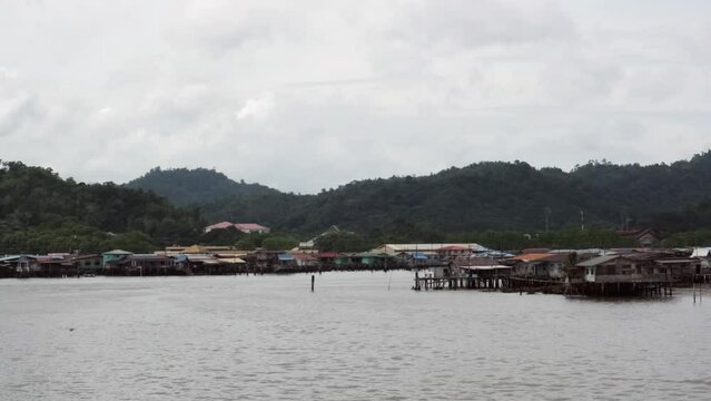 4K view of Kampong Ayer in Brunei with houses and green mountains with cloudy sky