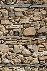 Old stone wall with wooden beams close