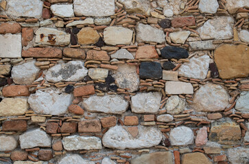 Old stone wall with ceramic pieces close