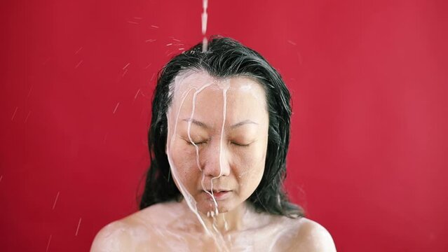 Asian woman washing her hair with pure coconut milk. Face of aesthetic model with splash, skin care and fruit for sustainable facial health and wellness. beauty portrait of woman for healthy skin.