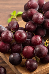 Delicious bunch of grapes fruit on a plate over wooden table background.