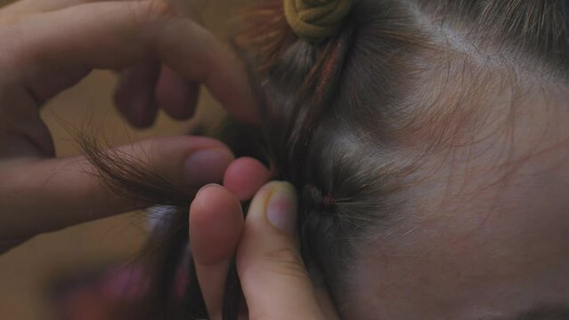 Process of weaving making boxer braids cornrows by a hair braider.