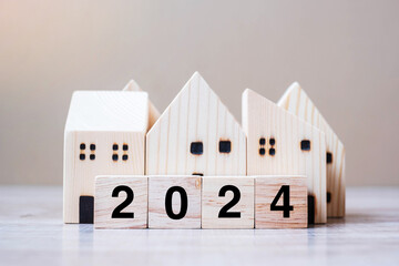 2024 Happy New Year with house model on table wooden background. Banking, real estate, investment,...