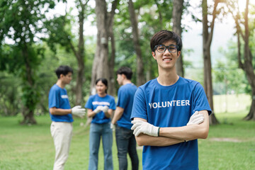 Volunteering, charity and clean environment concept. Happy man and group of volunteers with garbage bags cleaning area in park, copy space