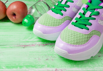 Fototapeta na wymiar pink sport shoes bottle of water and green apples
