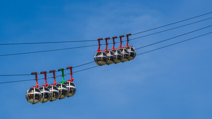 Gondola bubbles against the blue sky. Cable car taking tourists to Fort de La Bastille in Grenoble,...