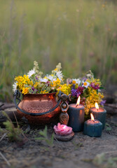 wiccan Goddess Candlestick, Copper witch cauldron with flowers, magic candles on meadow, abstract...